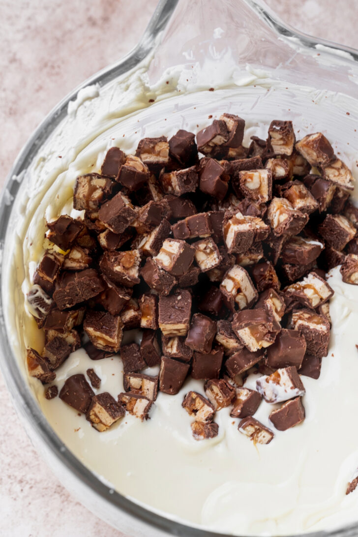 Snickers on top of cheesecake batter.