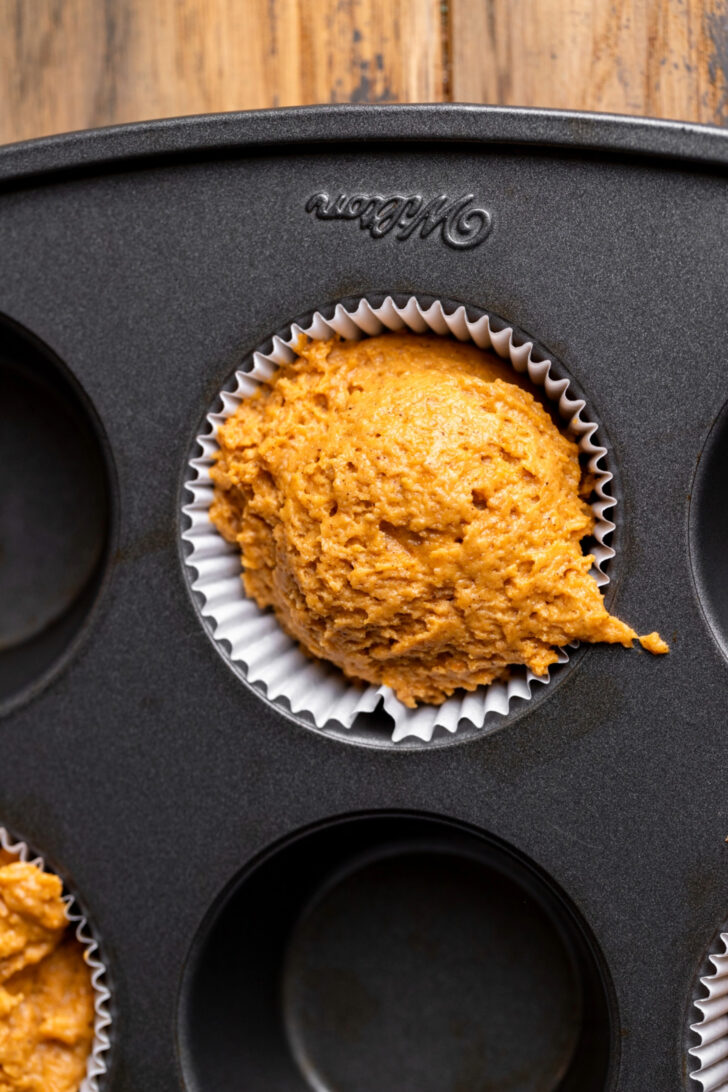 Muffin batter in a muffin pan.