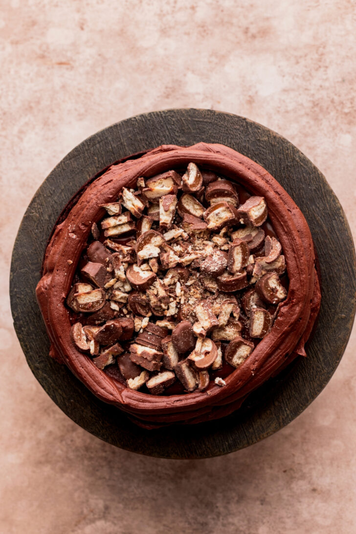 Chopped twix on top of cake.