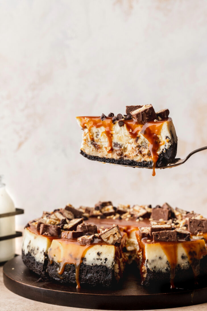 Taking a slice out of the Snickers cheesecake.
