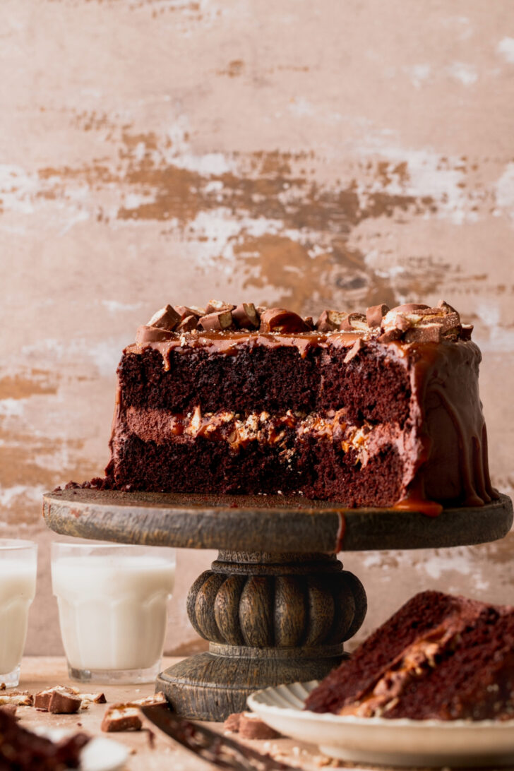 Side view of twix cake on a cake stand.