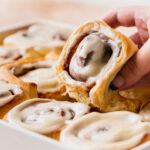 Pulling homemade cinnamon rolls out of the pan.