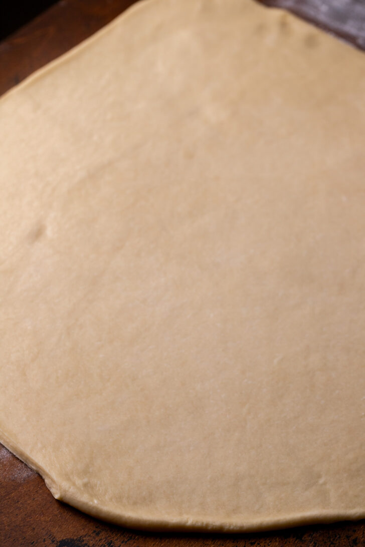 Rolled out dough on a wood board.