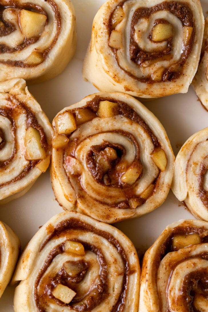 Raw cinnamon rolls in a pan.