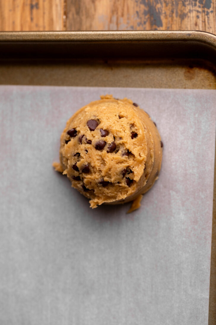 Cookie dough ball on parchment paper.