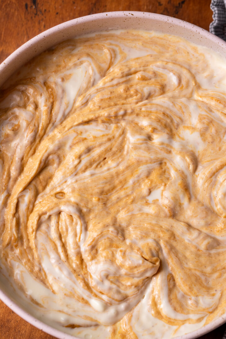 Pumpkin and cheesecake swirled together in a pan.