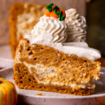 One slice of pumpkin cheesecake cake on a plate.