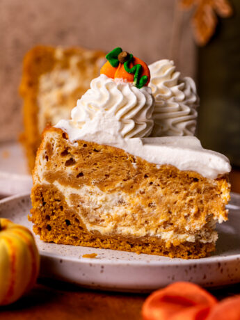 One slice of pumpkin cheesecake cake on a plate.
