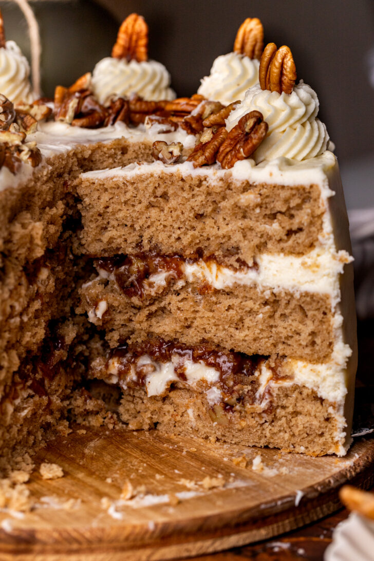 Taking a pecan pie cake slice out of the cake.