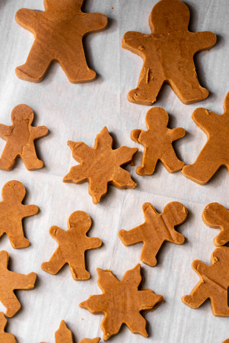 Cut out gingerbread men on parchment paper.