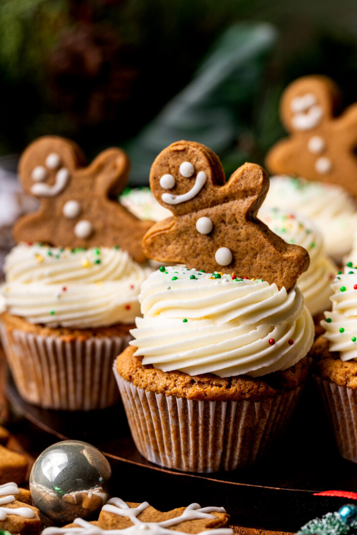 Side view of cupcakes on a wood board.