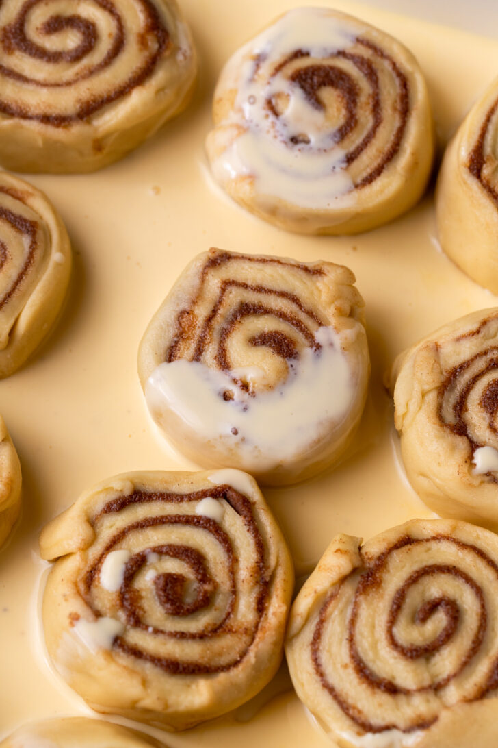 Eggnog on top of raw cinnamon rolls.