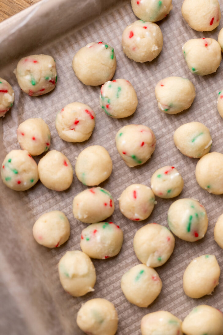 Cookie dough balls on a cookie sheet.