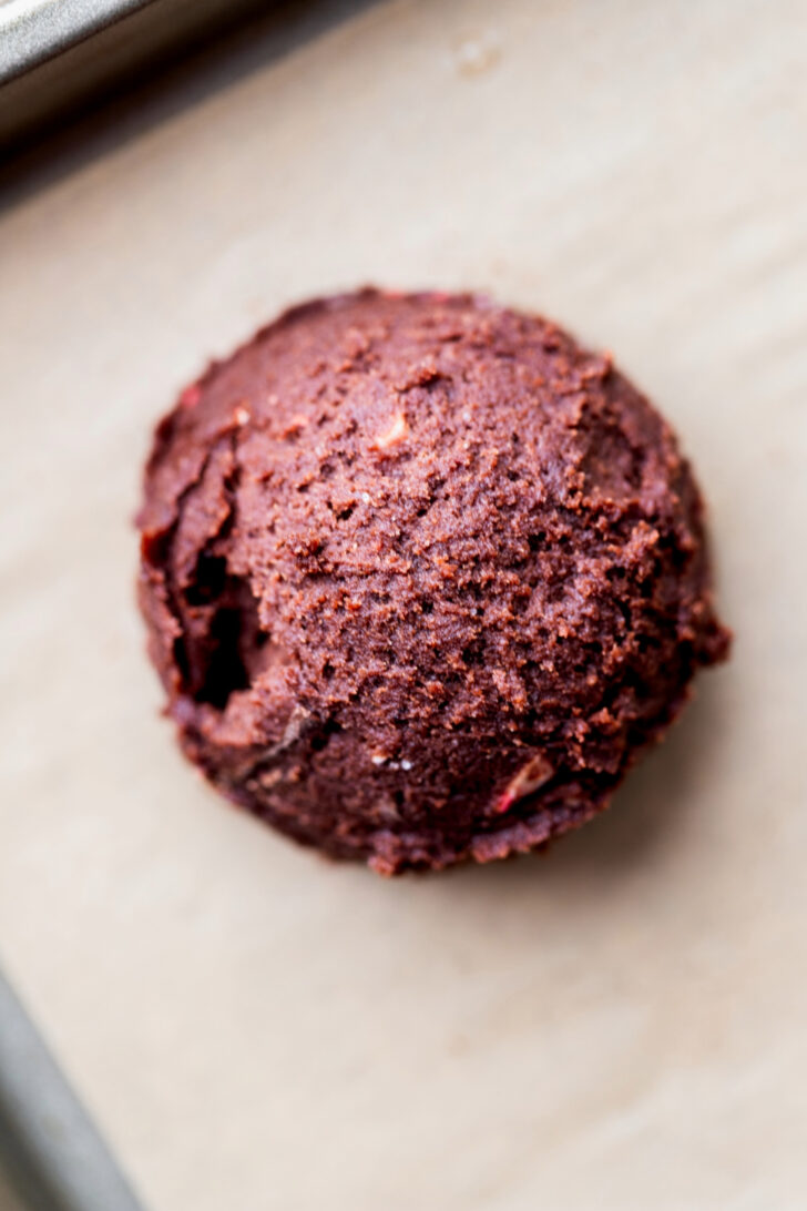 Chocolate cookie dough ball on parchment paper.
