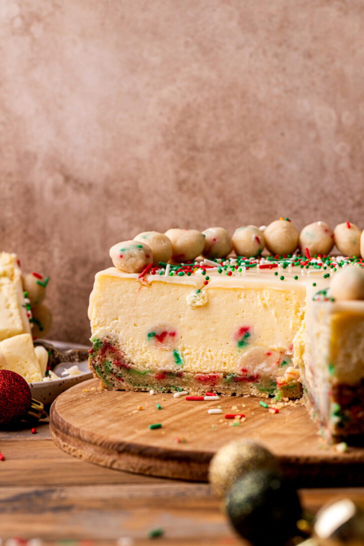 Sugar cookie cheesecake is opened up on a wood board.