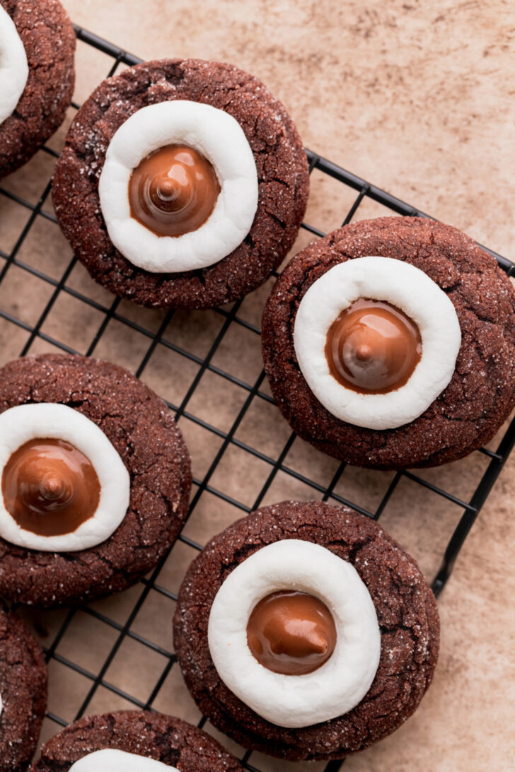 Hot cocoa cookie blossoms on wire rack.