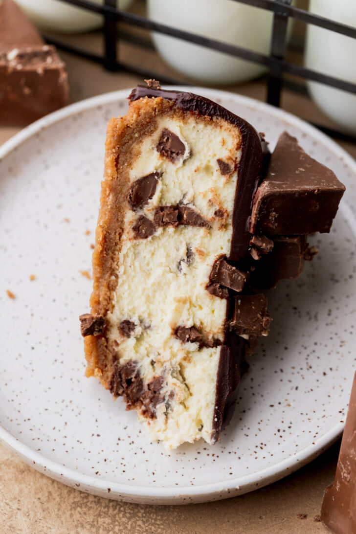 One slice of cheesecake on a plate on it's side.