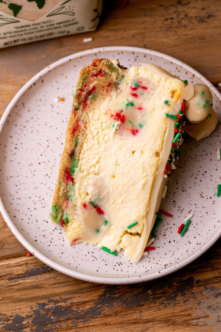 One slice of cheesecake on its side on a plate.