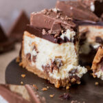 One slice of Toblerone cheesecake with a bite missing on a platter.