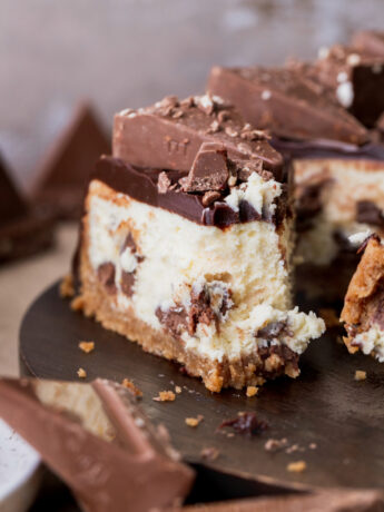 One slice of Toblerone cheesecake with a bite missing on a platter.