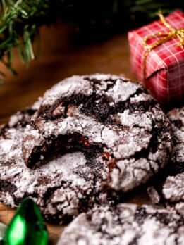 A bite missing from chocolate crinkle cookies.
