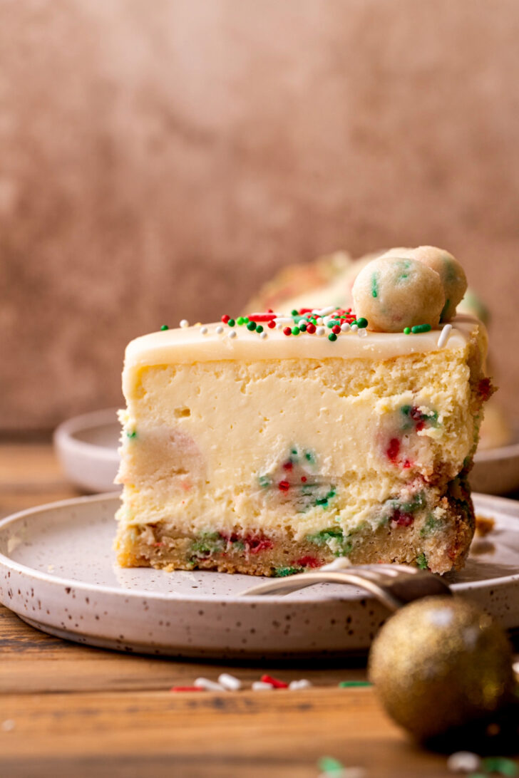 One slice on cheesecake on a plate standing up.