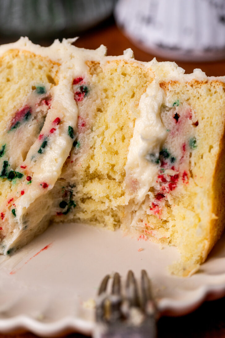 Bite missing from cake slice on a plate.