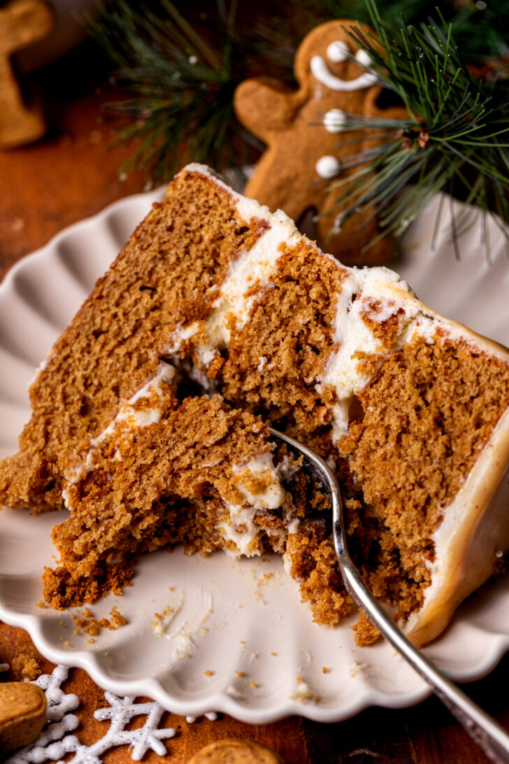 Gingerbread cake slice on a plate with a bite missing.