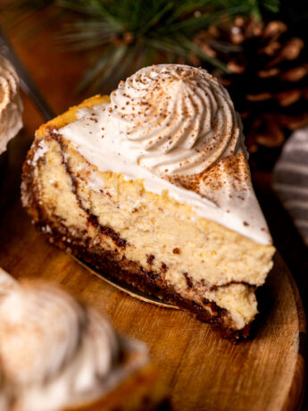 Slice of eggnog cheesecake on a wood platter.