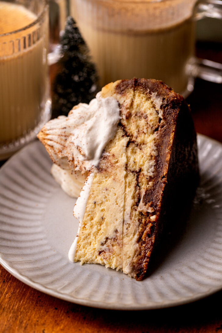 One slice of cheesecake on a plate on its side.