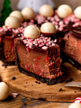 Bite missing from a slice of chocolate peppermint cheesecake.