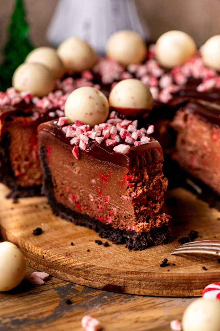 Bite missing from a slice of chocolate peppermint cheesecake.