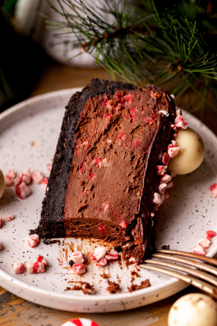 One slice of cheesecake on it's side on a plate.