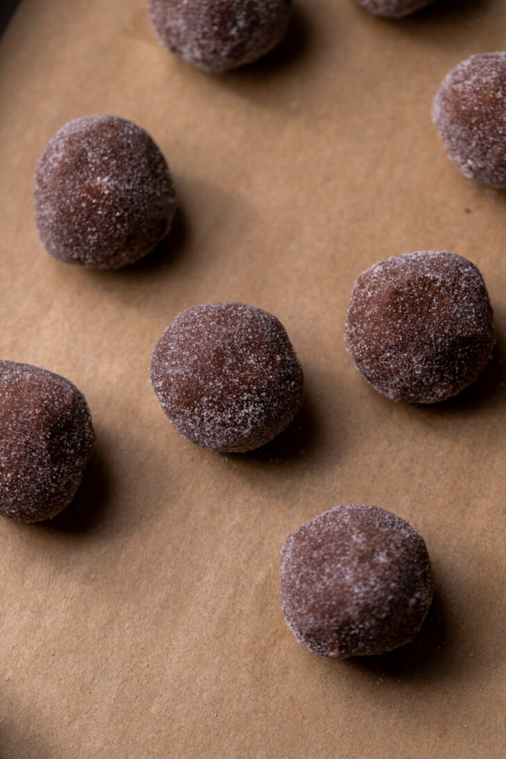 Rolled cookie dough balls on a cookie sheet.