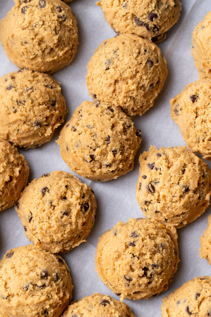 Cookie dough balls on parchment paper.