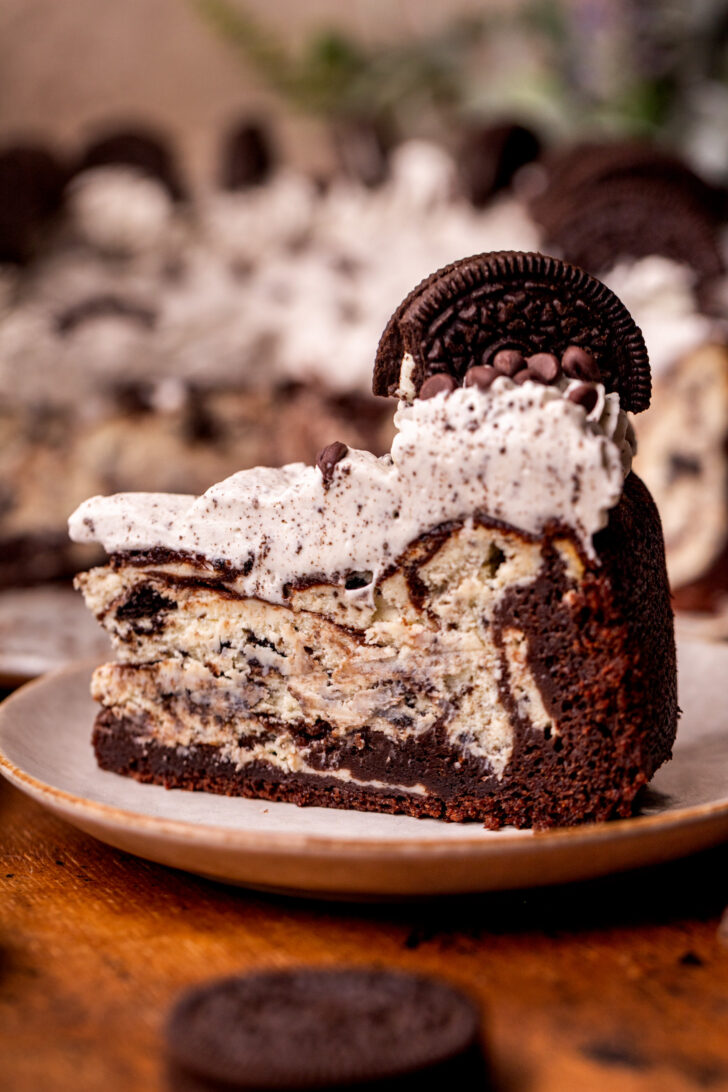 One slice of Oreo cake cheesecake on a plate.