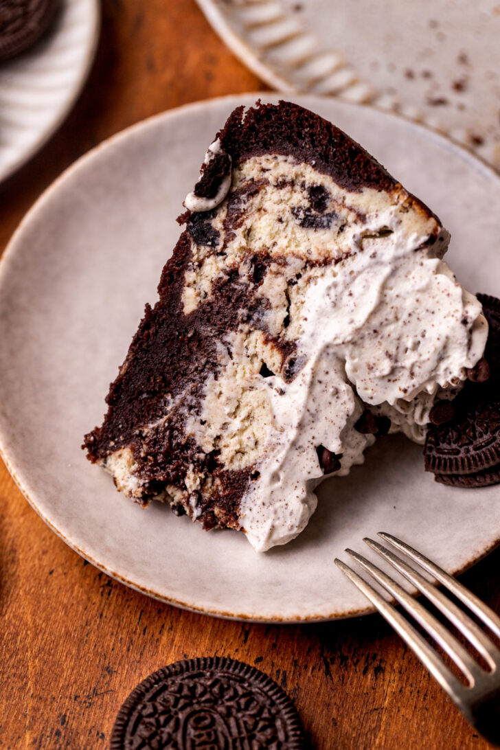 One slice of cheesecake on its side on a plate.
