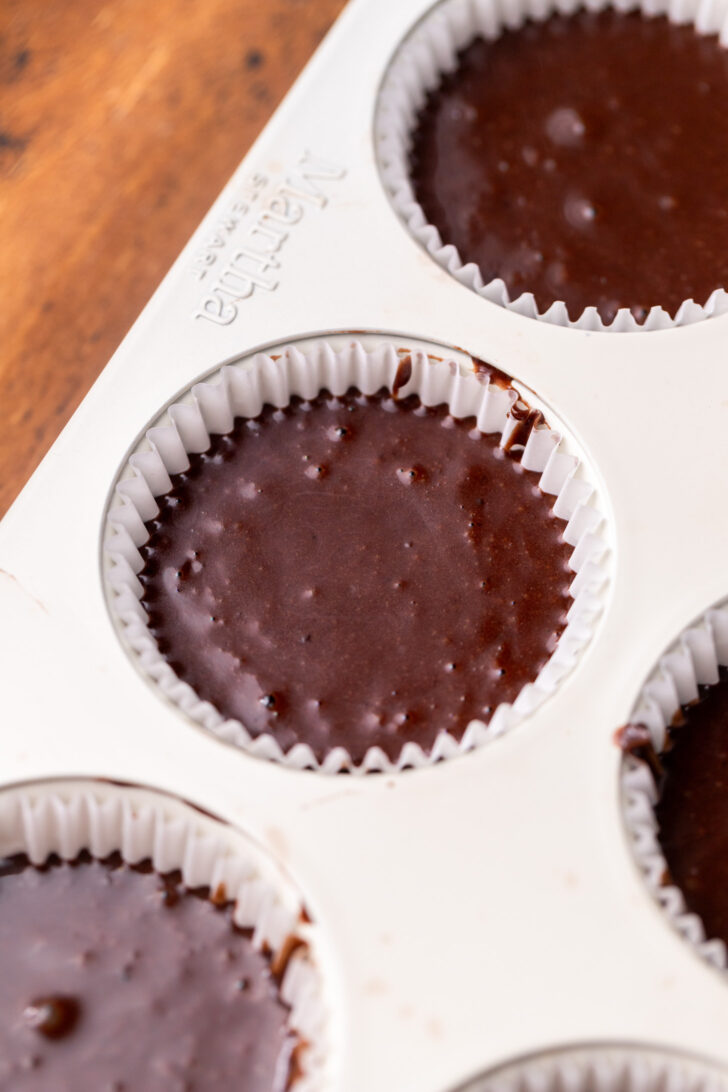 Chocolate cake batter in the cupcake pan.