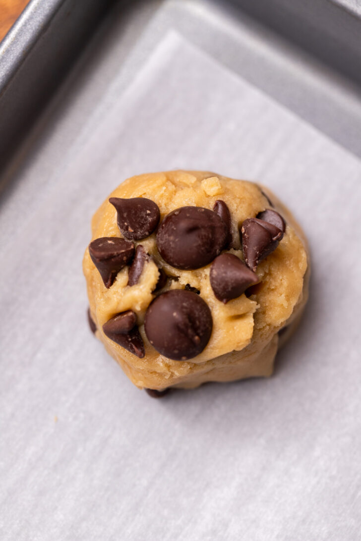 Cookie dough ball on top of cookie sheet.