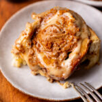 One Biscoff cinnamon roll on a plate.