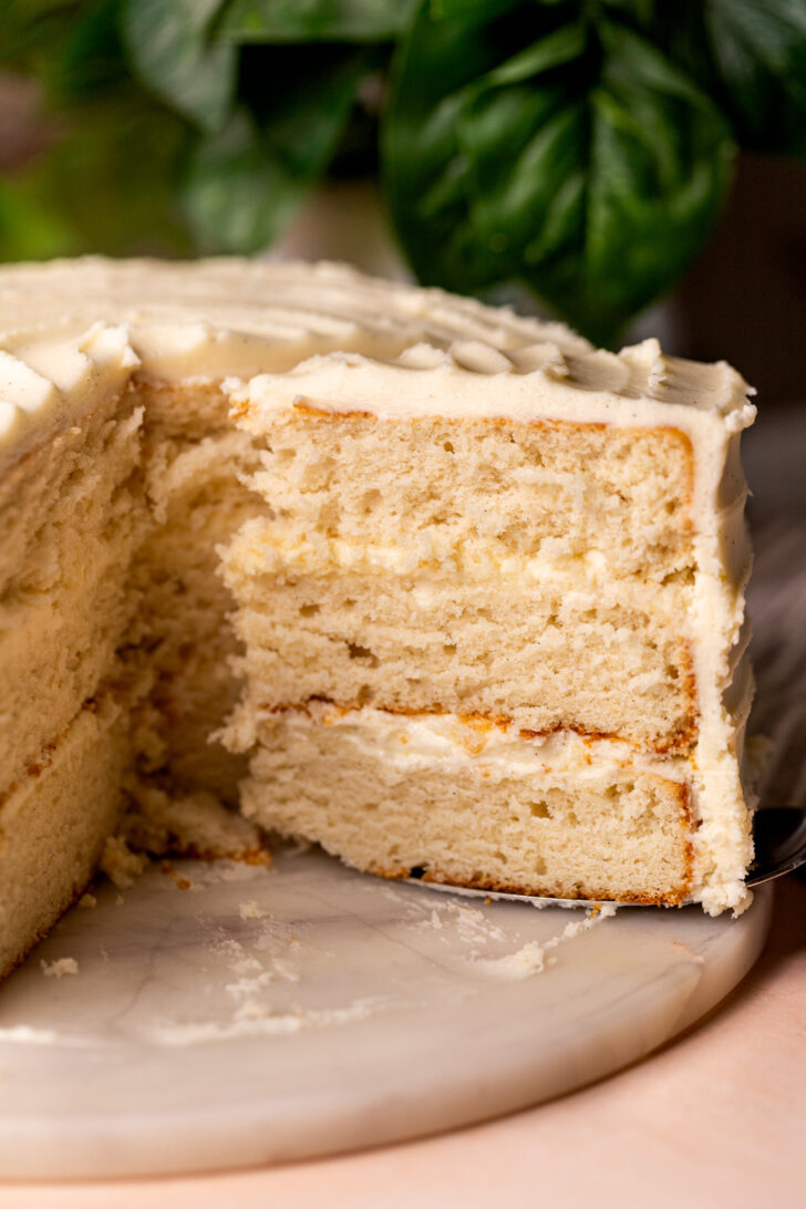 Taking a slice of vanilla cake out.