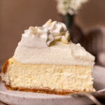 One slice of vanilla bean cheesecake on a plate.