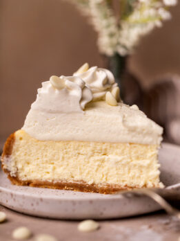 One slice of vanilla bean cheesecake on a plate.
