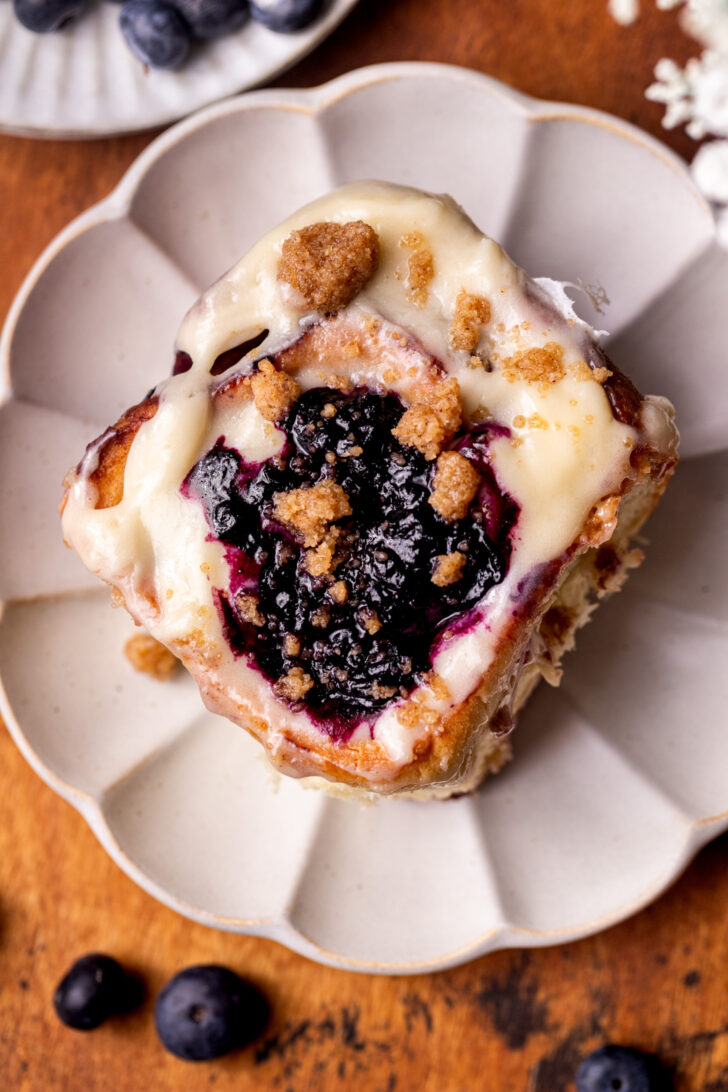 One blueberry muffin cinnamon roll on a plate.