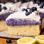 Slice of the lemon blueberry mousse cake by the whole cake.