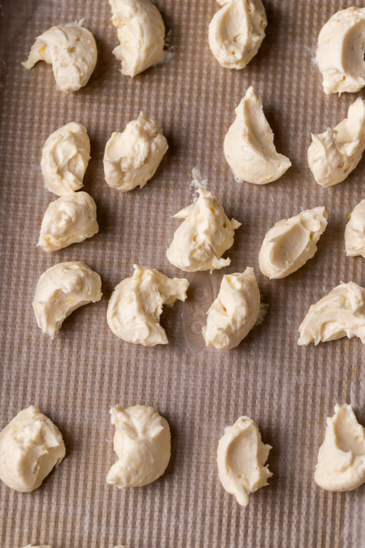 Cream cheese dollops on a cookie sheet.