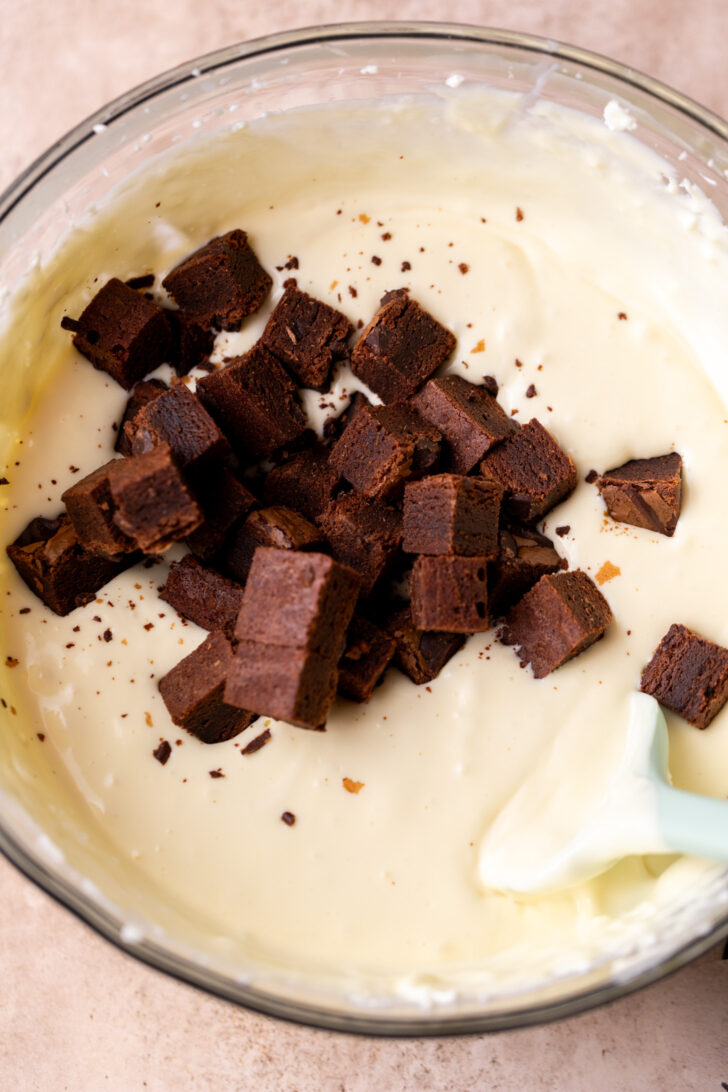 Brownie pieces on top of cheesecake batter.