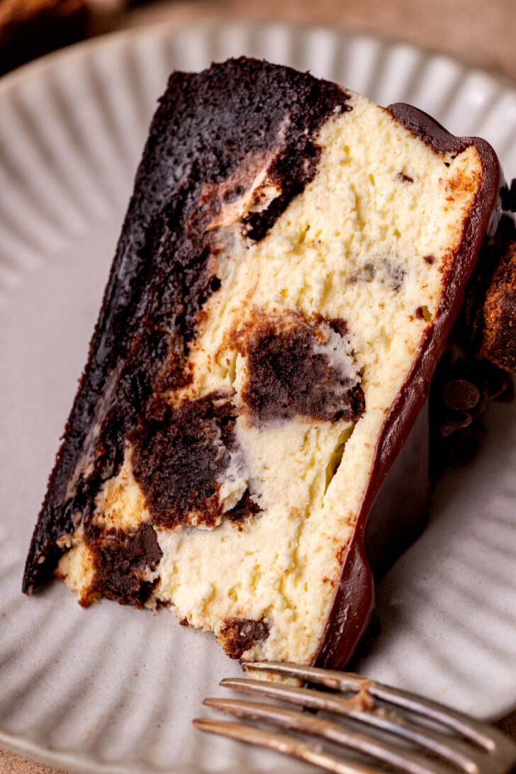A piece of cheesecake on it's side on a plate.