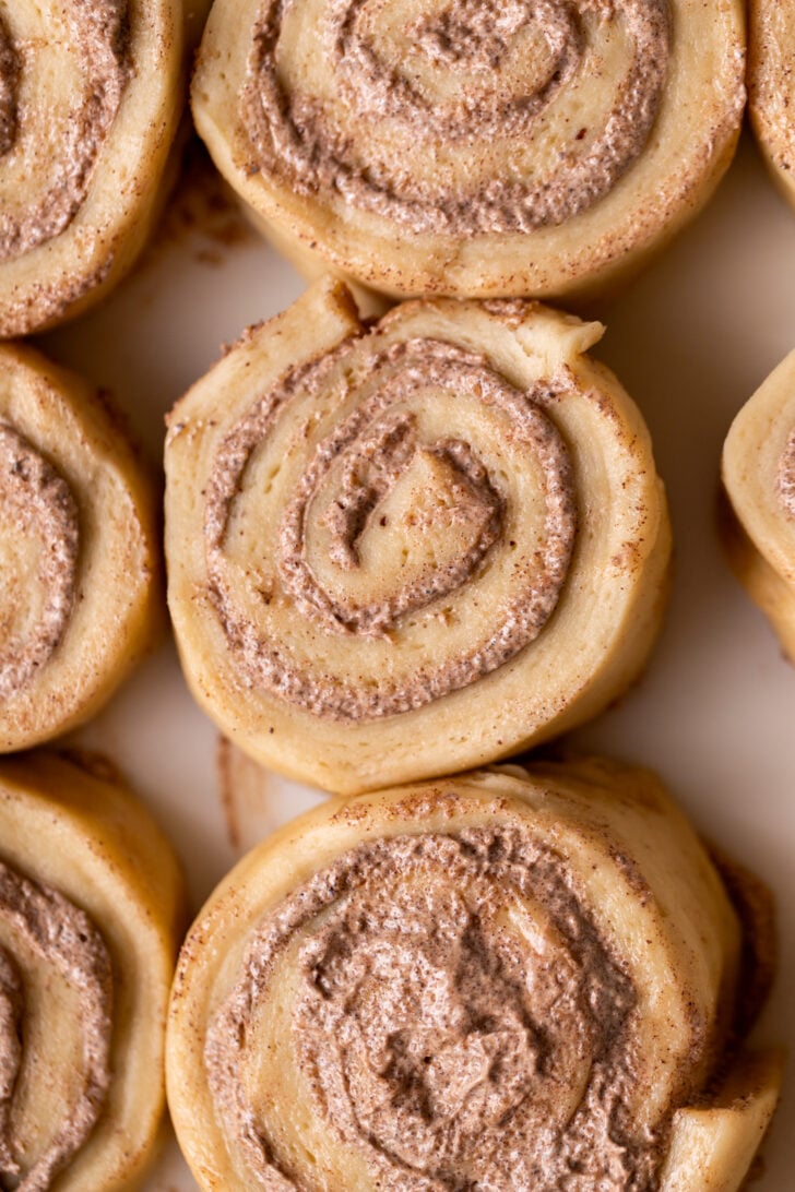 Raw cinnamon rolls in a pan.