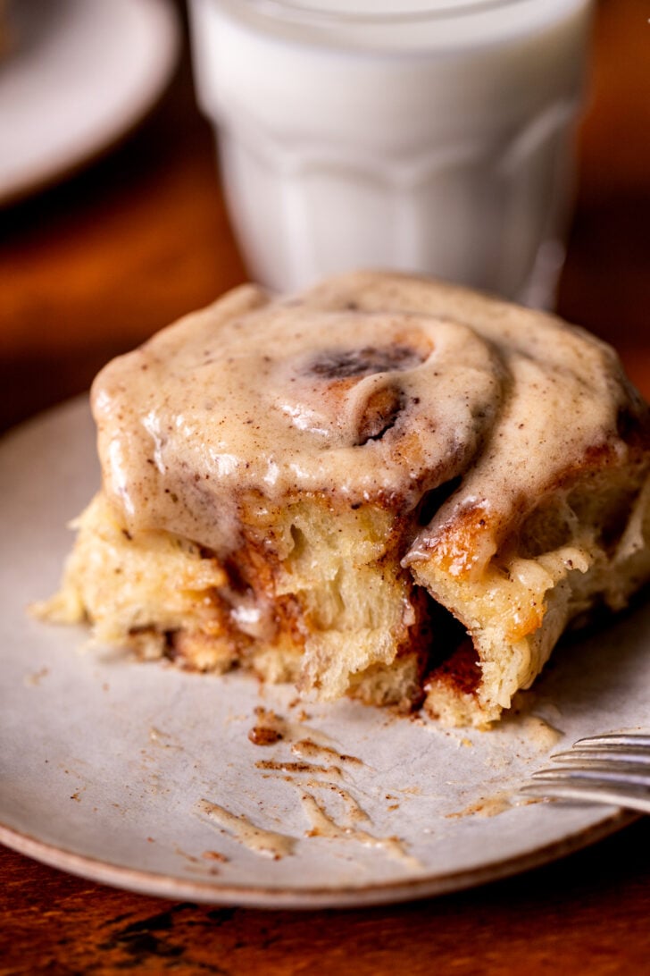 One brown butter cinnamon roll on a plate.